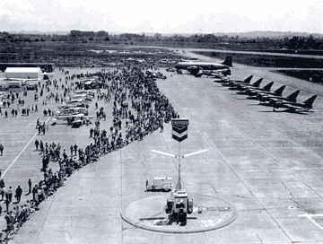 Photo of STS  in 1942, showing U.S. Army soldiers marching and planes lined up on the air field.